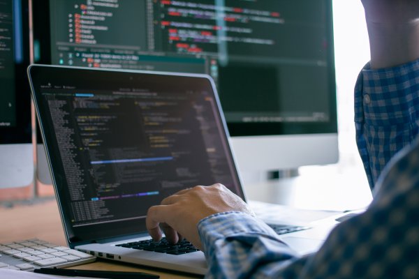 Person at a computer screen with code on the monitor